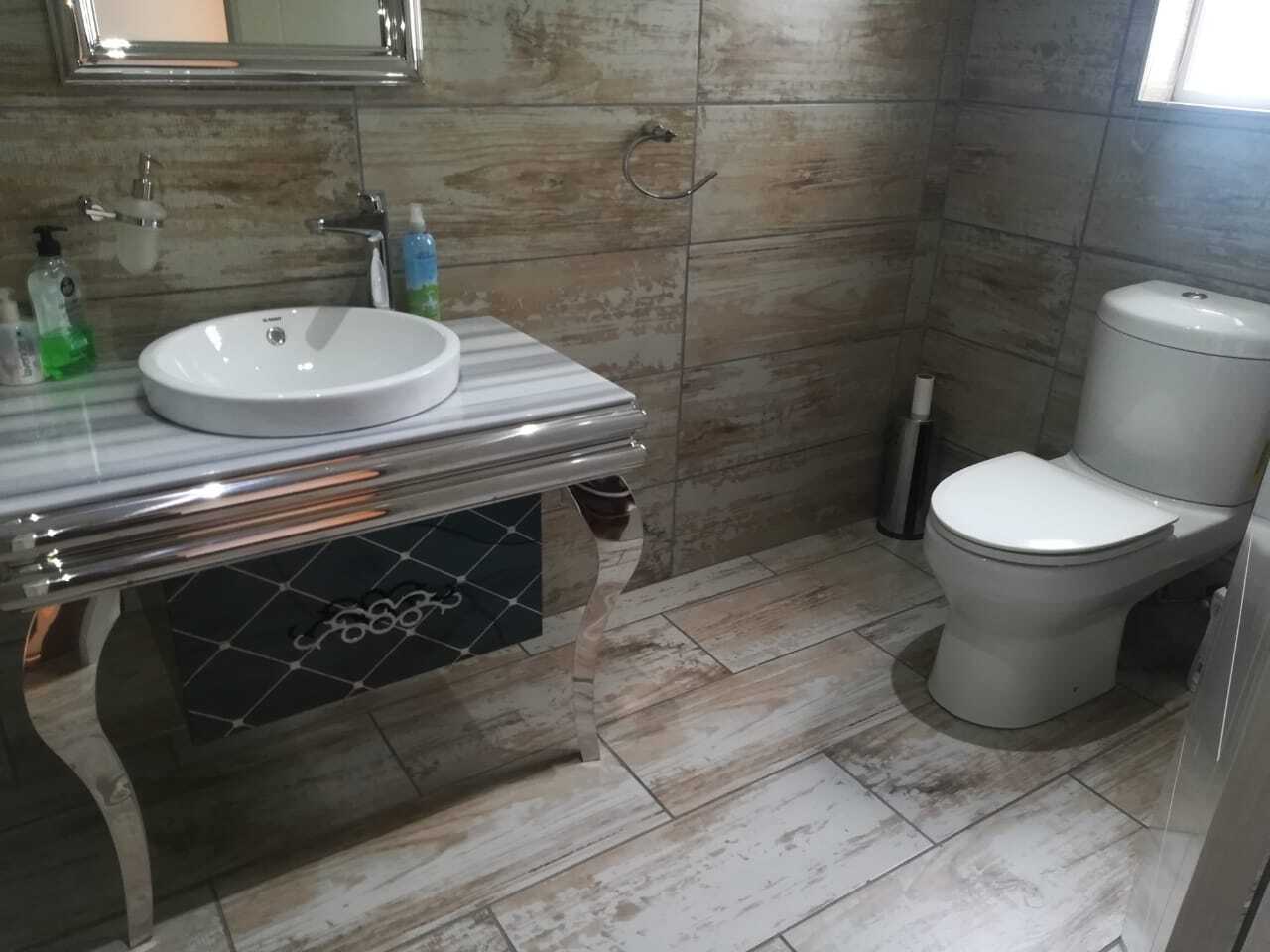 Vanity basin and chrome washstand in designer bathroom