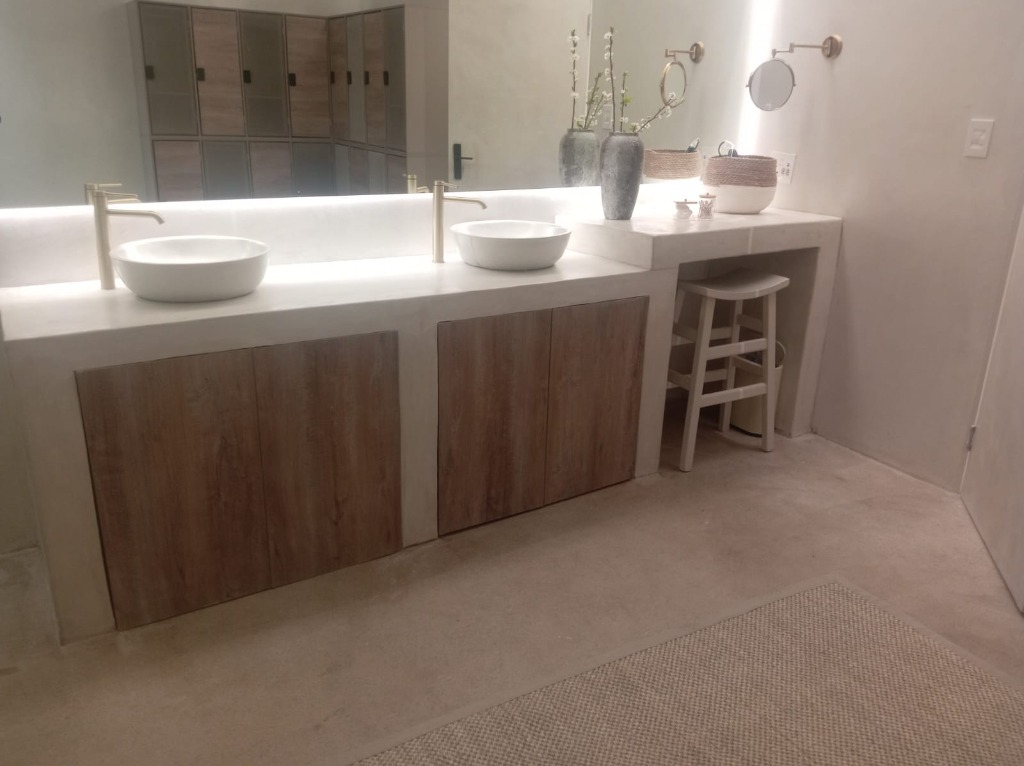 Custom concrete floating double basin vanity with brushed brass tapware and mirrors